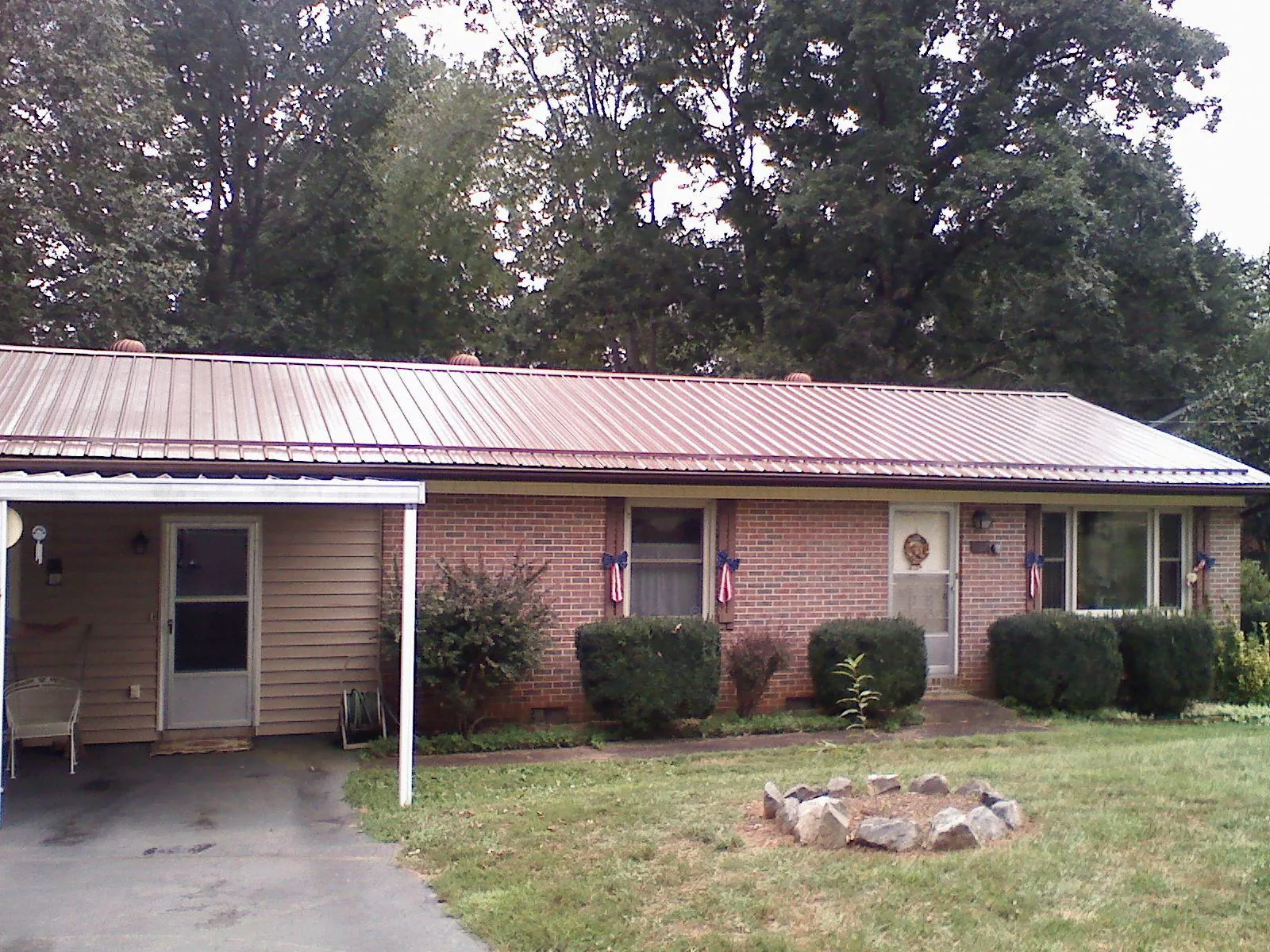 Bronze metal roof and carport on a brick ranch home in Steen